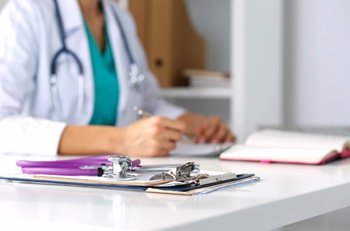 Healthcare worker sitting at a desk.